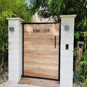 Entrée d'un hébergement insolite, porte en bois élégante entourée de bambous verdoyants.