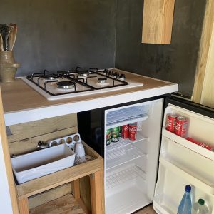 Cuisine d'un hébergement insolite avec un plan de travail en bois et un réfrigérateur.