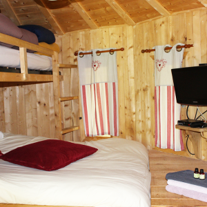 Chalet en bois chaleureux avec lit double, lit superposé et décor rustique. Parfait pour se