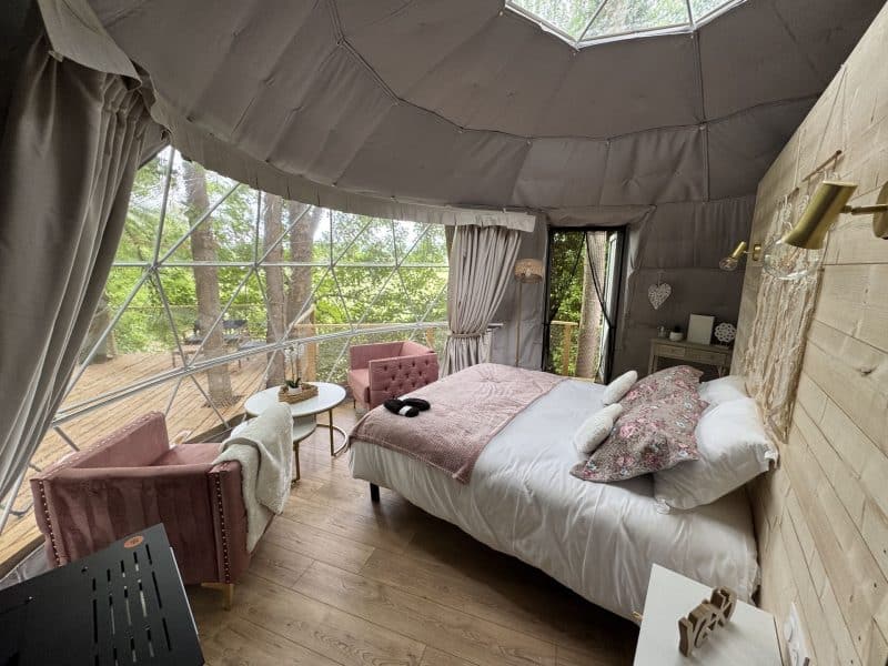 Dôme cosy avec vue sur la nature, lit douillet et décoration élégante.