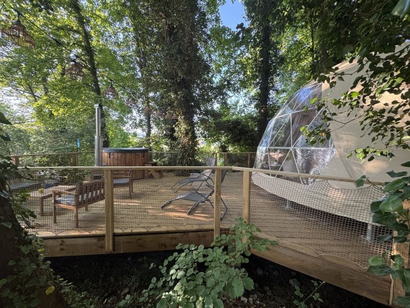 Dôme écologique en pleine nature, avec terrasse en bois et spa extérieur.