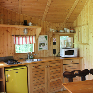 Cabane en bois chaleureuse avec cuisine équipée et ambiance rustique. Parfaite pour un séjour
