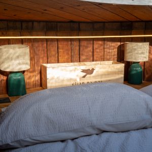 Chambre cocooning avec lit douillet, éclairage doux et décor en bois chaleureux.
