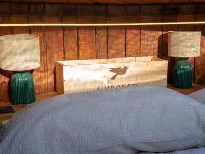 Chambre cocooning avec lit douillet, éclairage doux et décor en bois chaleureux.