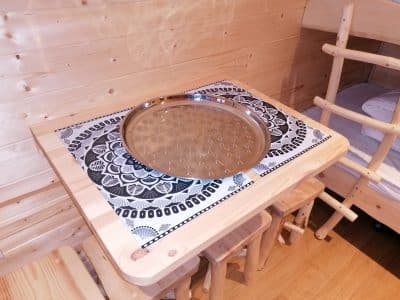 Table en bois avec plateau décoratif dans un hébergement insolite en bois.