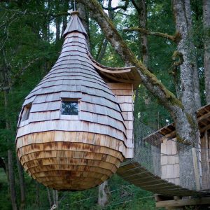 Cabane dans les arbres en bois, suspendue entre les arbres, offrant une vue imprenable.