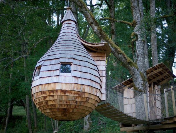 Cabane dans les arbres en bois, suspendue entre les arbres, offrant une vue imprenable.
