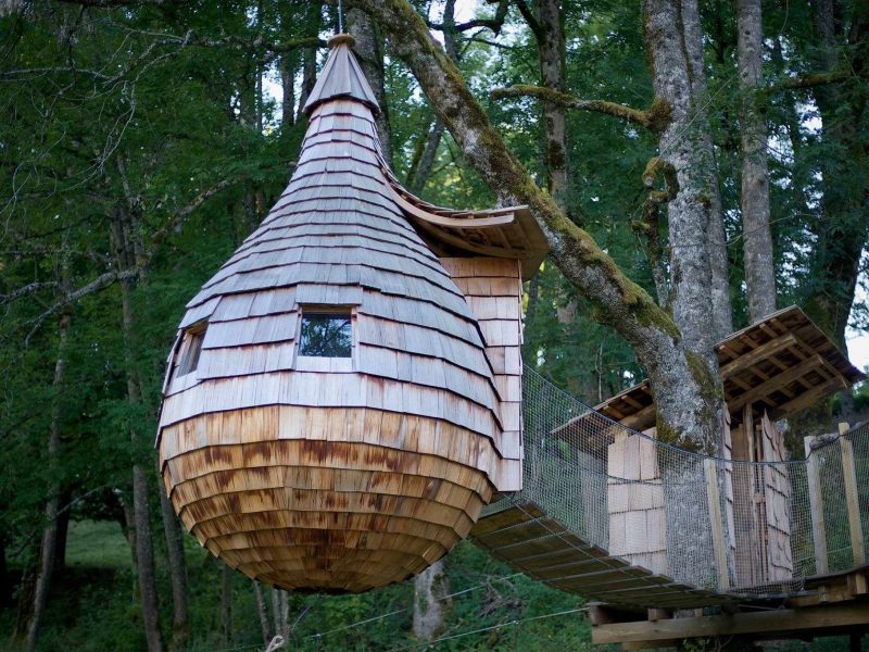 Cabane dans les arbres en bois, suspendue entre les arbres, offrant une vue imprenable.