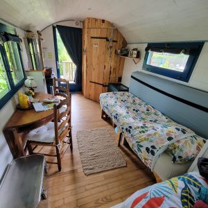 Tiny house chaleureuse avec un intérieur en bois et un coin repas accueillant.