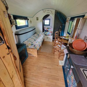 Tiny house chaleureuse avec lit douillet et décor coloré, ambiance cosy.