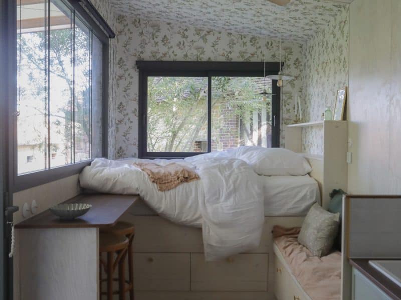 Chambre cosy en bois avec lit surélevé et vue sur la nature. Parfait pour un séjour relaxant.