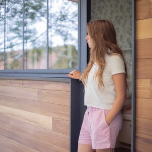 Chalet en bois avec grandes fenêtres, offrant une vue sur la nature environnante.
