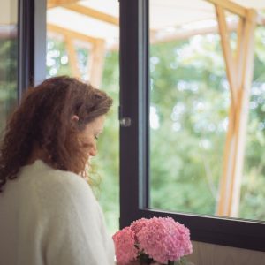 Hébergement insolite : intérieur lumineux avec vue sur la nature, décoré de fleurs roses.