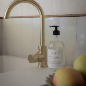 Élégante cuisine dun gîte, avec un robinet doré et des pommes fraîches.