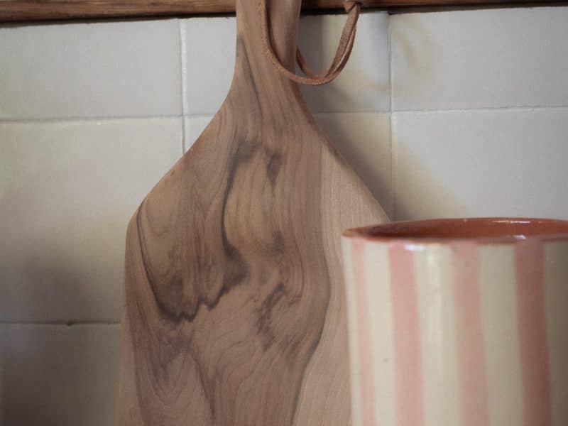 Planche en bois et tasse rayée dans un hébergement chaleureux et accueillant.