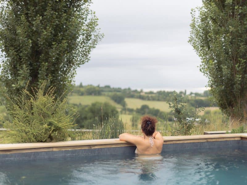 Hébergement de luxe avec piscine à débordement et vue panoramique sur la campagne.