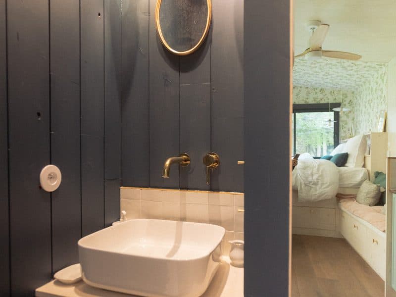 Salle de bain moderne dans un chalet, avec un lavabo élégant et des murs en bois.