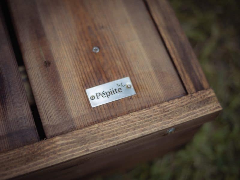 Cabane en bois avec une plaque en métal gravée "Pépite", ambiance chaleureuse et naturelle.