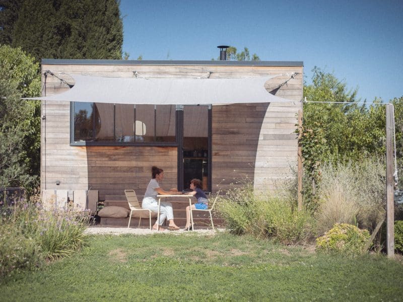 Charmante tiny house en bois avec terrasse ombragée, idéale pour se détendre.