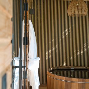 Cabane en bois avec un bain nordique et des peignoirs suspendus.