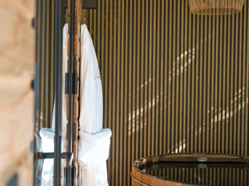 Cabane en bois avec un bain nordique et des peignoirs suspendus.