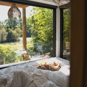 Chambre dhôtes moderne avec vue sur la nature et petit-déjeuner au lit.