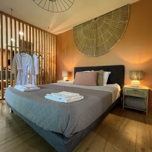 Chambre cosy avec lit double, décor chaleureux et touches naturelles, idéale pour un séjour