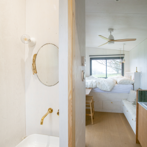 Chalet moderne avec salle de bain minimaliste et vue sur la nature, ambiance chaleureuse.