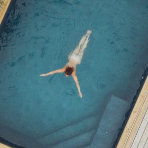 Hébergement avec piscine, un nageur se détend dans une eau cristalline.