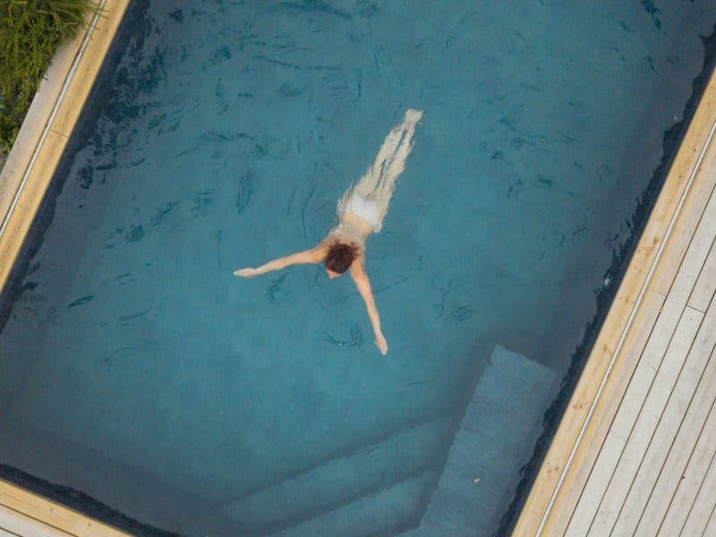 Hébergement avec piscine, un nageur se détend dans une eau cristalline.