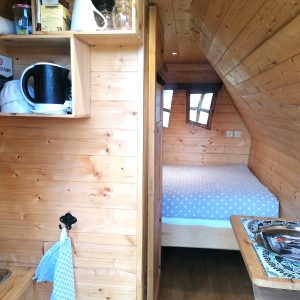 Cabane en bois cosy avec kitchenette, lit douillet et ambiance chaleureuse.