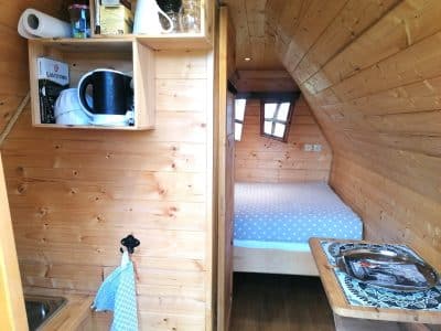 Cabane en bois cosy avec kitchenette, lit douillet et ambiance chaleureuse.
