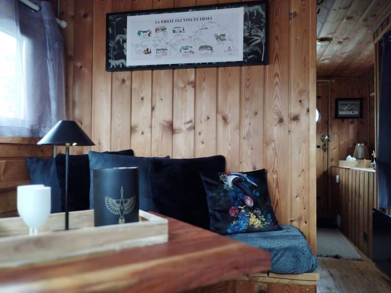 Cottage en bois chaleureux avec un coin salon confortable et décor élégant.