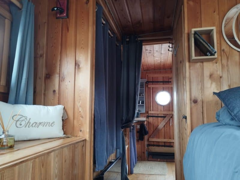 Intérieur dune cabane en bois, avec des rideaux et un lit confortable.