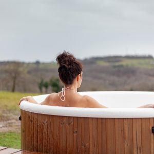 Bain nordique en bois, vue panoramique sur la nature verdoyante, ambiance relaxante.