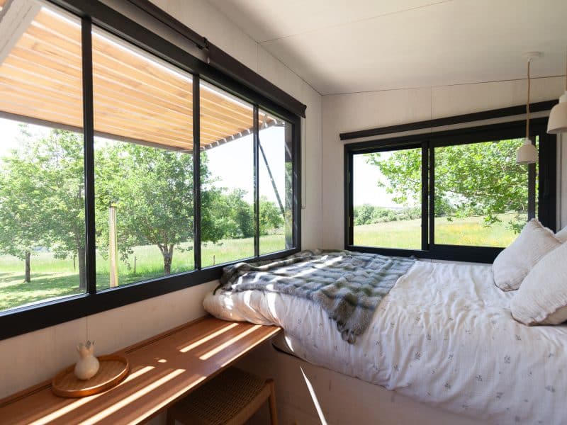 Chambre dhôtes lumineuse avec vue sur la nature et un lit confortable.
