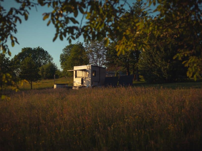 Cabane en bois entourée de verdure, offrant un cadre paisible et naturel.