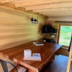 Intérieur d'une cabane en bois, avec une grande table en bois massif et des murs en lambris.