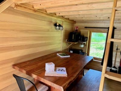 Intérieur d'une cabane en bois, avec une grande table en bois massif et des murs en lambris.