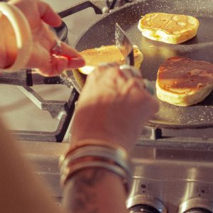 Séjour insolite en cabane, avec des pancakes dorés cuisinés sur une cuisinière moderne.
