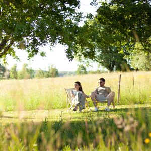 Détente en pleine nature dans un hébergement insolite, chaises longues sous les arbres.
