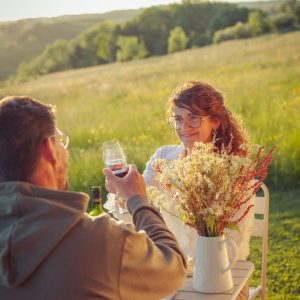 Détente en pleine nature dans un hébergement insolite, avec un verre de vin et des fleurs.