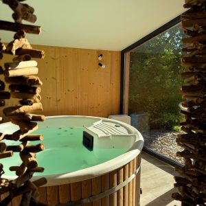 Hébergement insolite : spa en bois avec vue sur la nature, ambiance relaxante et moderne.