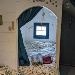 Chambre cocooning dans un hébergement romantique, décorée avec des draps fleuris.