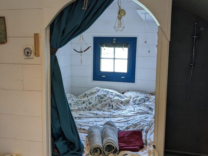 Chambre cocooning dans un hébergement romantique, décorée avec des draps fleuris.