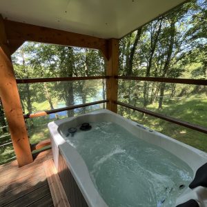 Cabane perchée avec jacuzzi, offrant une vue imprenable sur la nature environnante.