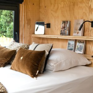 Chambre cosy en bois avec literie confortable et décor élégant, vue sur la nature.