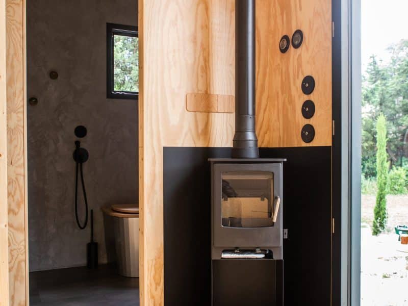 Cabane moderne avec poêle à bois et intérieur en bois chaleureux.