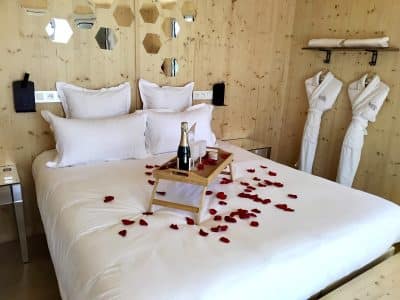 Chalet moderne avec lit douillet, pétales de rose et champagne pour une escapade romantique.