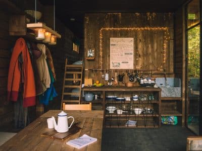 Cottage en bois chaleureux avec cuisine équipée, ambiance cosy et décor rustique.